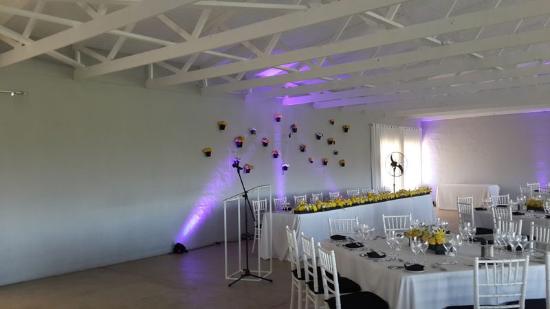 Purple uplighting in a white wedding venue